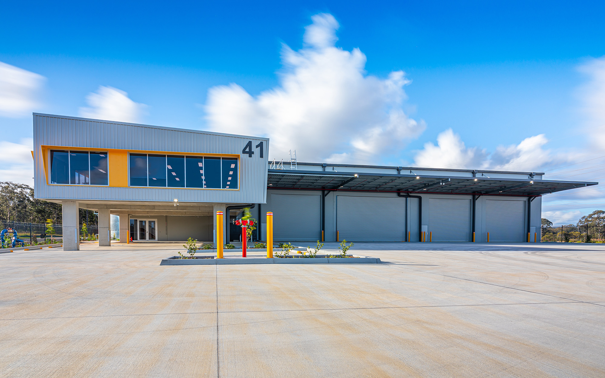 Modern industrial warehouse and office facility with multiple roller doors